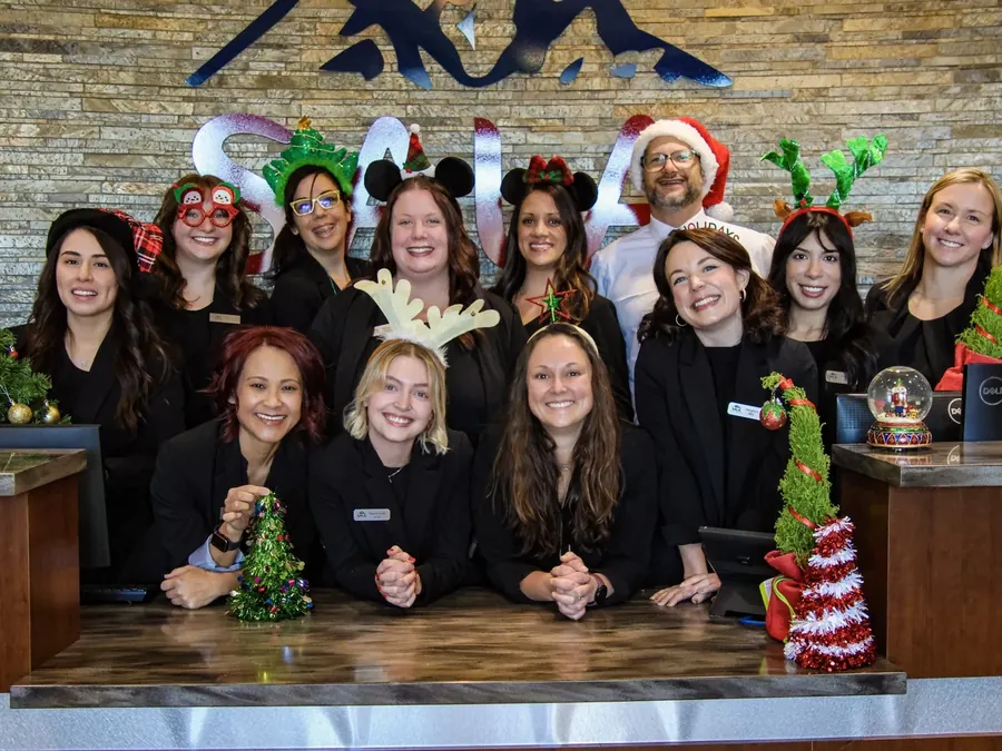 The Sala team in holiday hats at the front desk.