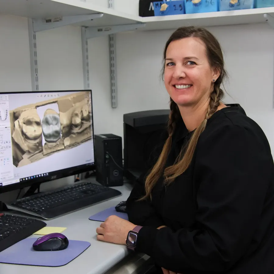 A lab team member designing a restoration on a computer.
